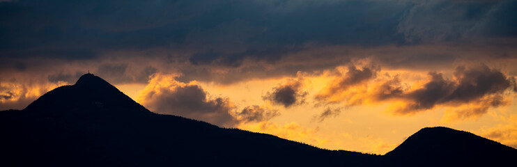 Stunning view of the silhouette of a mountain range during a dramatic sunset.