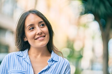 Young hispanic woman smiling happy standing at the city.