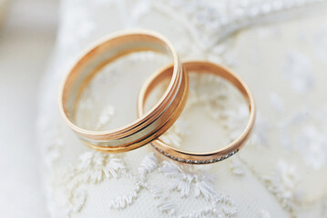 Obraz na płótnie Canvas golden wedding rings on a white lace background. wedding ceremony