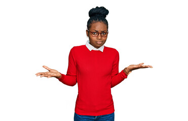 Young african american woman wearing casual clothes and glasses clueless and confused expression...