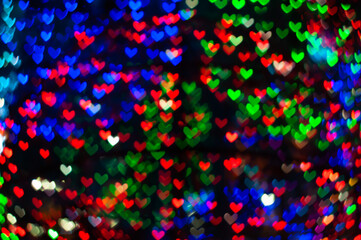 Color Bokeh on a dark background with hearts for use in graphic design
