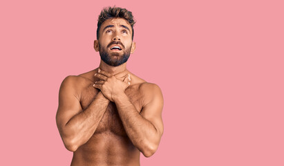 Fototapeta premium Young hispanic man wearing swimwear shirtless shouting and suffocate because painful strangle. health problem. asphyxiate and suicide concept.