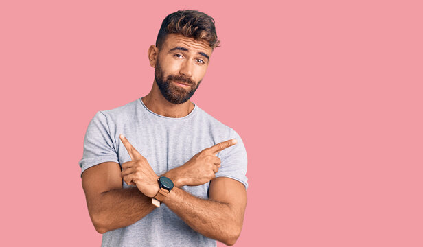 Young hispanic man wearing casual clothes pointing to both sides with fingers, different direction disagree