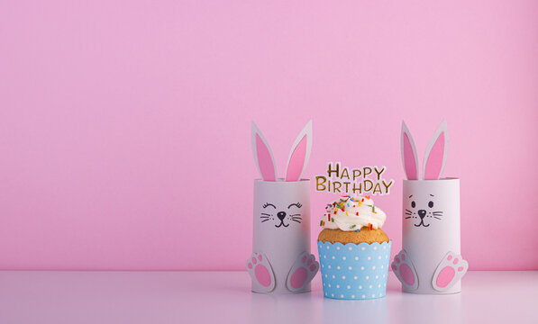 Cute Paper Rabbits From A Roll Of Toilet Paper With The Cake On His Birthday. Background For The Birthday Party