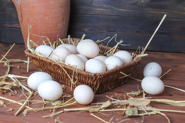 fresh eggs in a basket on wooden table.