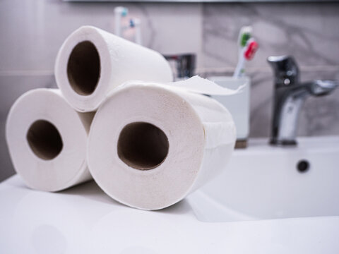 Rolls of paper on a sink in a white bathroom