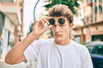 Young caucasian man with serious expression walking at the city.