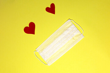Disposal protective masks and a red heart on a yellow background.