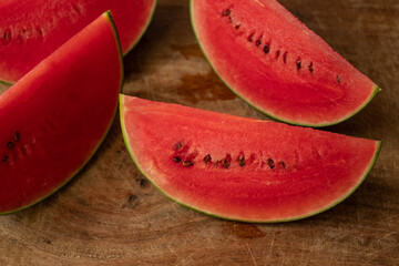 Small watermelon slices on wooden board