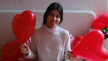 Joyful girl waving red balloons valentines day