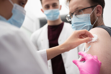 A young nurse shows a medical intern how to properly administer the injections. A sterile doctor's office in a private clinic. The COVID vaccine19.