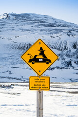 Warning road sign "Hide your valuables" located at the Athabasca Glacier touristic site, in the Canadian Rockies