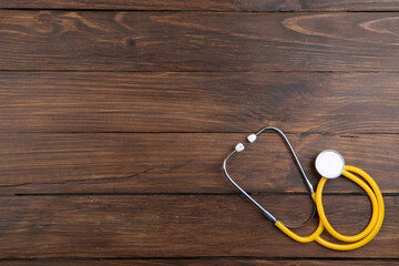 Workplace of a doctor. Stethoscope and little heart on wooden desk background