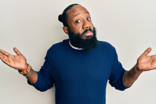 Young african american man wearing casual clothes clueless and confused with open arms, no idea and doubtful face.