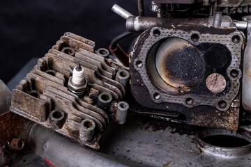 Repair of a small internal combustion engine from a lawn mower. Head, cylinder and piston of a four-stroke engine.