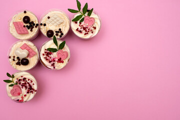 Sweet small homemade trifle dessert with custard, chocolate, nuts and fruits and decorations and cream cheese.