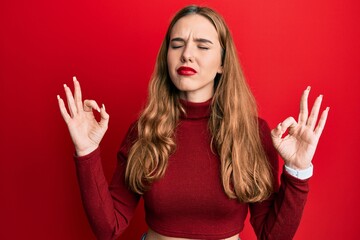 Young blonde woman wearing turtleneck sweater relax and smiling with eyes closed doing meditation gesture with fingers. yoga concept.