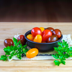 Red, Yellow, Orange Grape Tomatoes in Bronze Bowl on Wooden Table