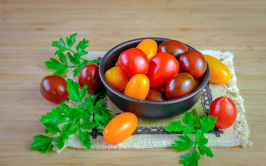 Fototapeta na wymiar Red, Yellow, Orange Grape Tomatoes in a Bronze Bowl on Bamboo Cutting Board