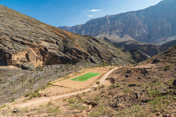 A green soccer field in the desert mountains of Oman. © Emily_M_Wilson
