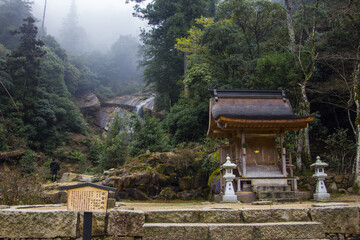Selective focus shot of a temple in a park on a foggy day in Miyajima, Japan