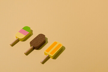 Colorful sunlit popsicles on a pale yellow background. Minimal ice cream layout.