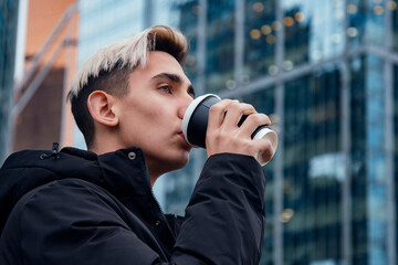 Handsome young man drinking morning coffee.
Everyday life in a big city.