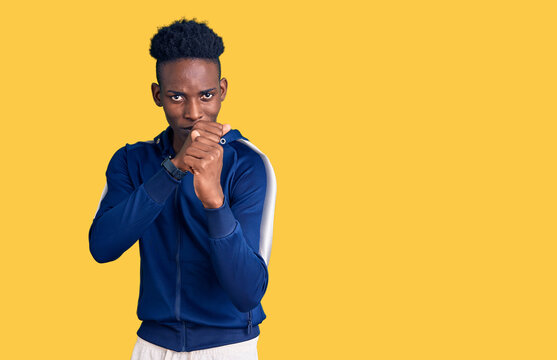 Young african american man wearing sportswear ready to fight with fist defense gesture, angry and upset face, afraid of problem