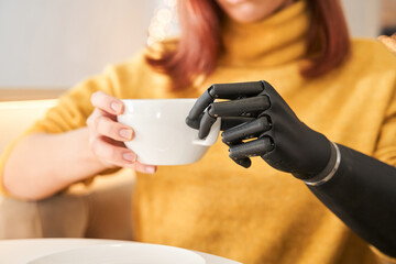 Woman with artificial limb sitting alone at restaurant