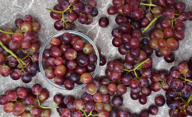 Overhead of fresh red grapes on the vine with marble counter 