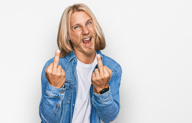 Caucasian man with blond long hair wearing casual denim jacket showing middle finger doing fuck you...