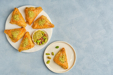 Sweets arabic dessert baklava, warbat, kunafa, kadayif with pistachio and cheese . Top view, copy space