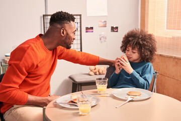 Father and son communicating at the table during breakfast