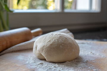 Fresh pasta dough on wooden cutting board
