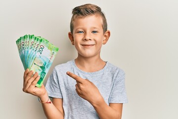 Adorable caucasian kid holding russian 200 ruble banknotes smiling happy pointing with hand and finger