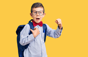 Cute blond kid wearing nerd bow tie and backpack screaming proud, celebrating victory and success very excited with raised arms