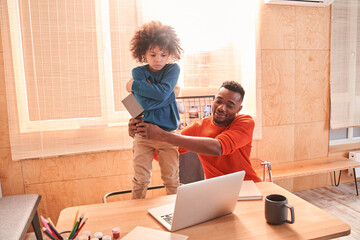 Multiracial child standing on a chair and refuses to do homework