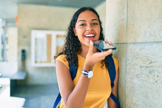 Young african american student girl smiling happy sending audio message using smartphone at university.