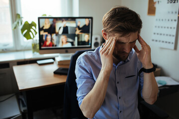 Mental health. Man Fatigue during home video conference meeting call. Post-work exhaustion from...