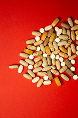 Fototapeta na wymiar White medical pills composition on red background. Flat lay, layout and tabletop mockup with copy space.