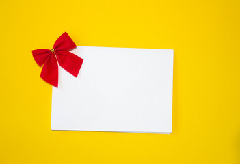 Valentine's day congratulation. Red rose and greeting card with heart sign on yellow background top view copy space