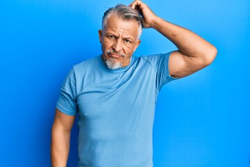 Middle age grey-haired man wearing casual clothes confuse and wonder about question. uncertain with doubt, thinking with hand on head. pensive concept.