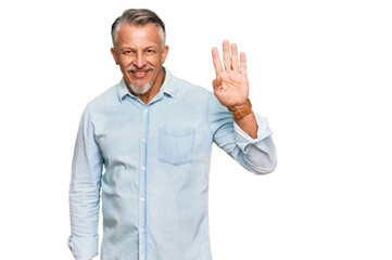 Middle age grey-haired man wearing casual clothes waiving saying hello happy and smiling, friendly welcome gesture