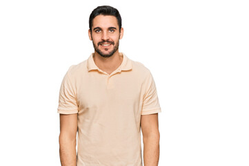 Fototapeta premium Young hispanic man wearing casual clothes looking positive and happy standing and smiling with a confident smile showing teeth