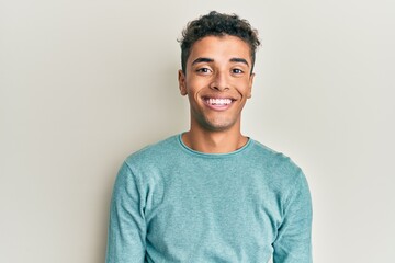 Young handsome african american man wearing casual clothes with a happy and cool smile on face....