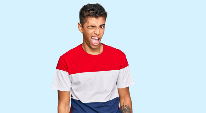 Young handsome african american man wearing casual clothes winking looking at the camera with sexy expression, cheerful and happy face.