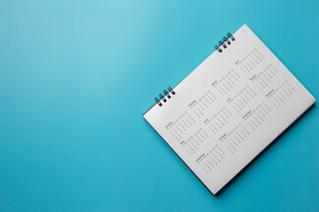 Calendar on solid blue background with copy space, business meeting schedule, travel planning or project milestone and reminder concept.