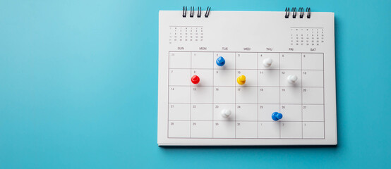 Calendar on solid blue background with copy space, business meeting schedule, travel planning or project milestone and reminder concept.