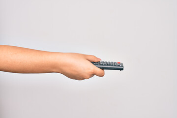 Hand of caucasian young woman changing television channel holding tv remote control over isolated white background