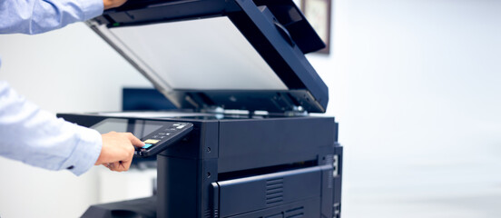 Bussiness man Hand press button on panel of printer, printer scanner laser in office copy machine supplies start concept.